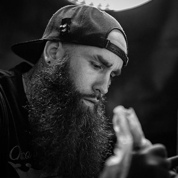 Tattoo artist at work using FYT tattoo supplies in a New York studio, focused expression.