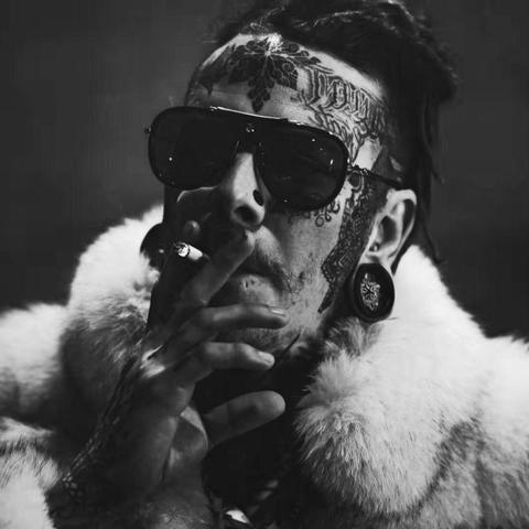 Tattooed man with facial and hand tattoos, sunglasses, and fur coat, FYT Tattoo Supplies New York