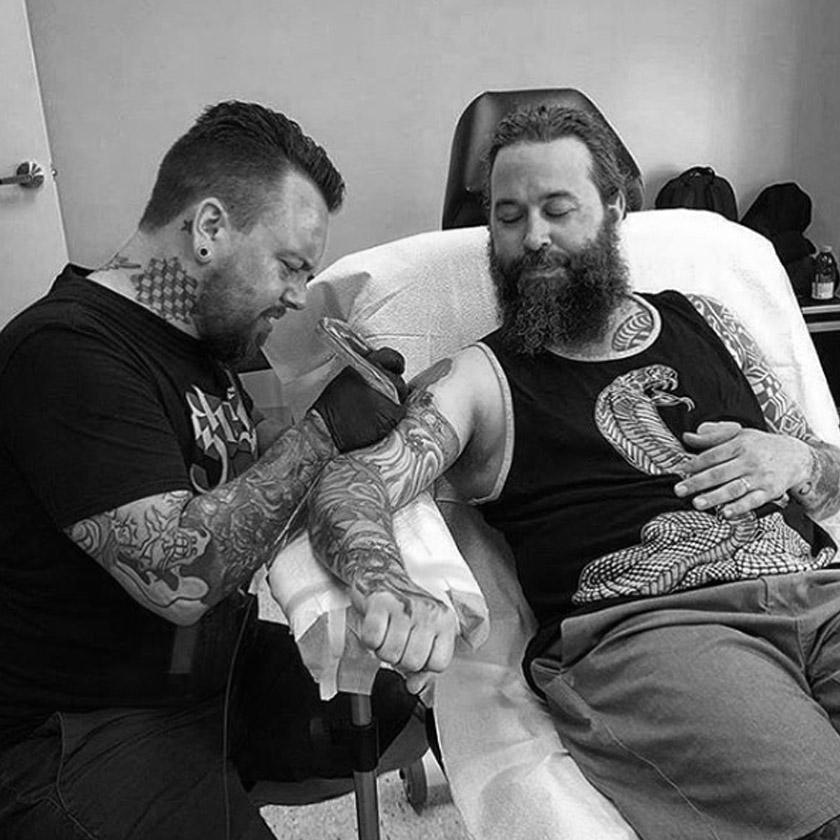 Tattoo artist using FYT tattoo supplies in New York studio with client receiving arm tattoo