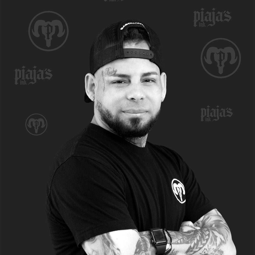 Tattooed man in black shirt and cap, promoting FYT Tattoo Supplies New York